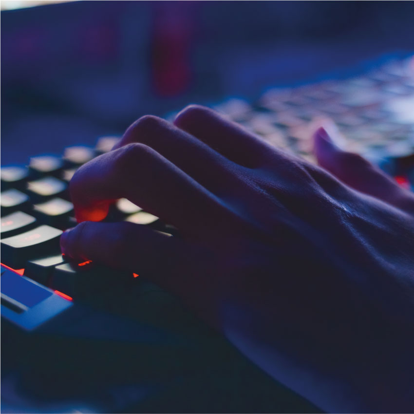 Une main tape sur un clavier d'ordinateur