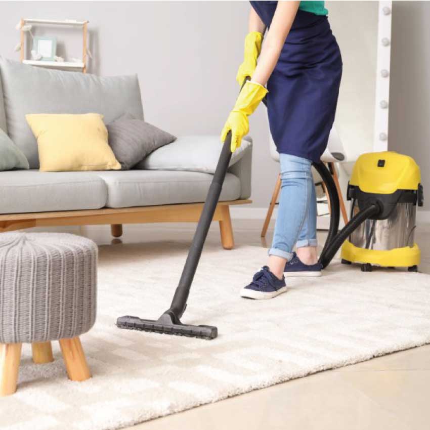 Une femme de ménage passe l'aspirateur