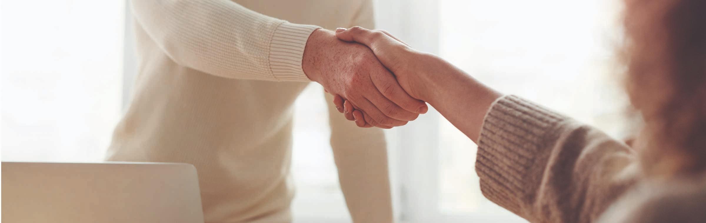 Un homme et une femme se serrent la main lors d'un entretien